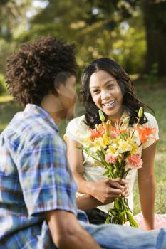 Royalty Free Photo of a Man Giving a Smiling Woman a Bouquet of Flowers