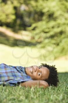 Royalty Free Photo of a Man Lying in the Grass in a Park Smiling
