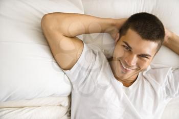 Royalty Free Photo of Handsome Man Lying With Hands Behind His Head and Smiling