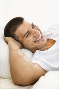 Royalty Free Photo of a Handsome Man Lying With Hands Behind His Head and Smiling