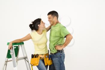 Royalty Free Photo of a Couple With Tools and a Ladder Standing in Home Smiling