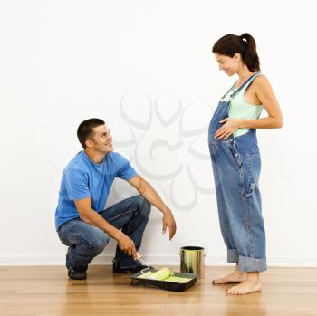 Royalty Free Photo of a Pregnant Woman and Husband Preparing to Paint a Wall