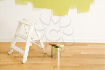 Royalty Free Photo of a Still Life of a Paintbrush on a Paint Can With a Stepladder Painted Wall