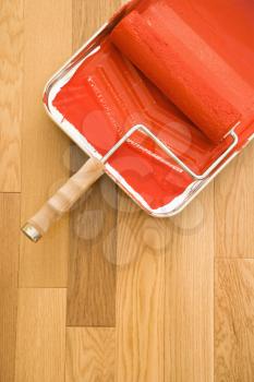 Royalty Free Photo of a Still Life of a Paint Roller in a Tray on a Wood Floor