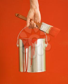 Royalty Free Photo of a Woman Holding a Paintbrush and Paint Can