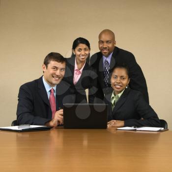 Royalty Free Photo of Businesspeople Gathered Around a Laptop Computer Smiling
