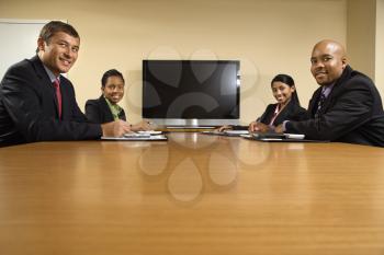 Royalty Free Photo of Businesspeople Sitting at a Conference Table Smiling