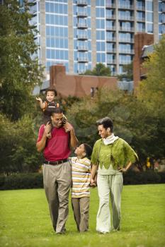 Royalty Free Photo of a Family Walking in a Park Smiling