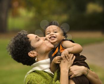 Royalty Free Photo of a Mother Holding and Kissing Her Son as he Smiles