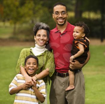 Royalty Free Photo of a Portrait of a Happy Smiling Family of Four in a Park