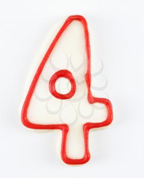 Royalty Free Photo of a Sugar Cookie in the Shape of a Number Four Outlined in Red Icing