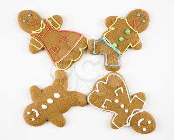 Four male and female gingerbread cookies arranged with feet touching.