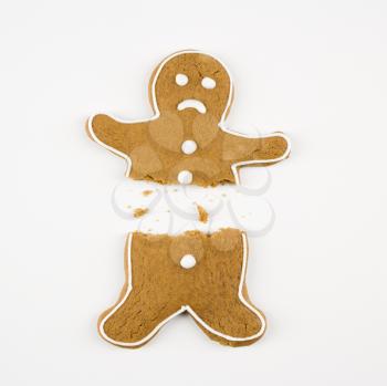 Frowning male gingerbread cookie broken in half.