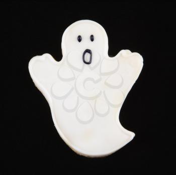 Sugar cookie in shape of a ghost with decorative icing.