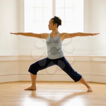 Royalty Free Photo of a Woman Doing Yoga Warrior Pose