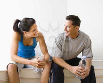 Royalty Free Photo of a Couple Sitting and Talking While Holding Water Bottles