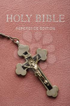 Royalty Free Photo of a Crucifix on a Rosary Lying the Cover of a Closed Holy Bible