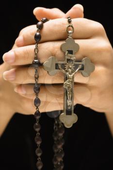 Woman holding rosary with crucifix.