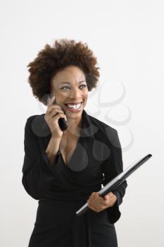 Businesswoman talking on cellphone smiling against white background.