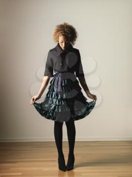 Royalty Free Photo of a Woman in a Pretty Ruffled Dress Holding The Hem Out to the Sides