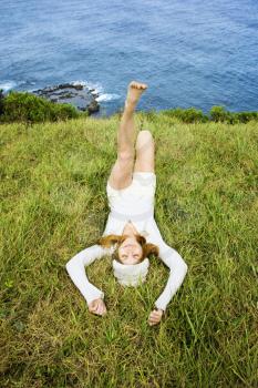 Royalty Free Photo of a Woman Relaxing in Grass Near the Ocean in Maui, Hawaii
