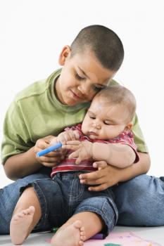 Royalty Free Photo of a Young Boy Holding His Baby Brother on His Lap