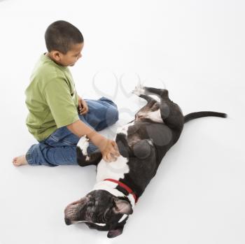 Royalty Free Photo of a Boy Petting a Dog on the Floor