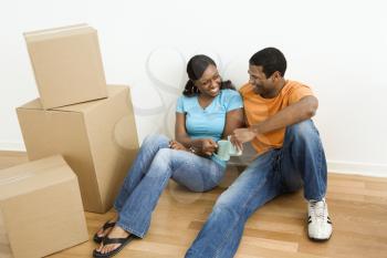 Royalty Free Photo of a Couple Sitting on a Floor Next to Moving Boxes