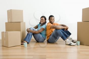Royalty Free Photo of a Couple Sitting on a Floor Next to Moving Boxes