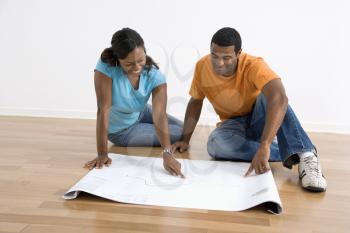 Royalty Free Photo of a Couple Looking at Architectural Blueprints 