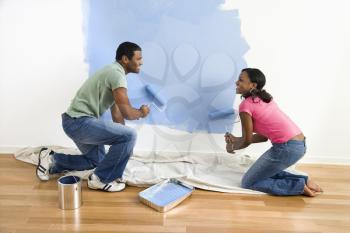 Royalty Free Photo of a Couple Painting a Wall Blue