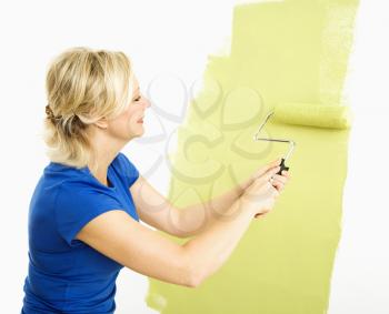 Royalty Free Photo of a Middle-aged Woman Painting a Wall