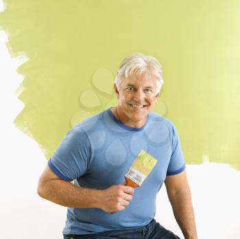 Royalty Free Photo of a Smiling Man Holding a Paintbrush