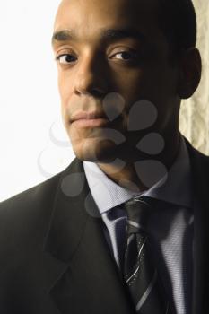 Cropped close-up portrait of an African-American mid-adult businessman. Vertical format.