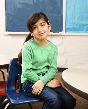 Young female student sitting in classroom. Vertically framed shot.