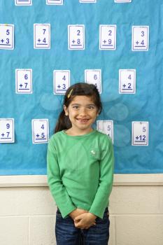 Young female student standing in front of a board of flash cards. Vertically framed shot.