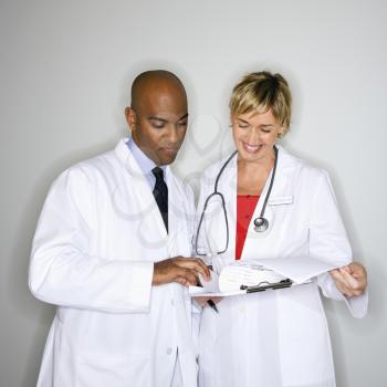 Male and female doctors reading paperwork.