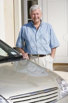 Royalty Free Photo of a Man Outside His House Beside a Car