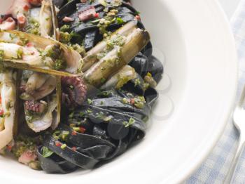 Royalty Free Photo of Sauteed Razor Clams with Baby Octopus Pesto and Tagliatelle Nero