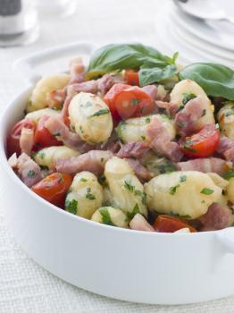 Royalty Free Photo of a Bowl of Gnocchi with a Bacon Tomato and Basil Dressing