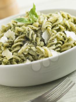 Royalty Free Photo of a Bowl of Fusilli Pasta Dressed in Pesto With Parmesan Shaves