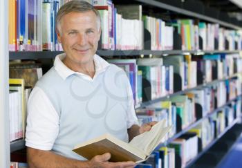 Royalty Free Photo of a Man Reading a Book in a Library