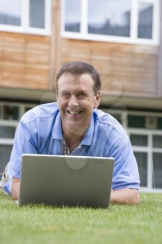 Royalty Free Photo of a Man on a School Lawn With a Laptop