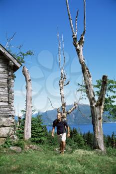 Royalty Free Photo of a Man Hiking By a Cabin