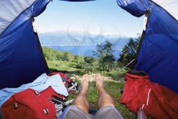 Royalty Free Photo of a Man's Legs in a Tent Overlooking Hills