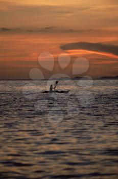 Royalty Free Photo of a Kayaker on the Water at Sunset