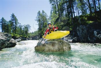 Royalty Free Photo of a Kayaker on a Rock