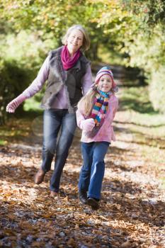 Royalty Free Photo of a Woman and Her Granddaughter Running Up a Path
