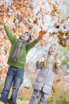 Royalty Free Photo of Two Children Playing in the Leaves