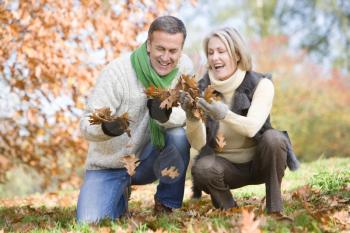 Royalty Free Photo of a Couple Playing in the Leaves